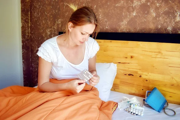 Zieke vrouw in bed met medicijnen. Om ziek thuis te blijven en pillen te nemen. verkoudheid. Traditionele geneeskunde. — Stockfoto