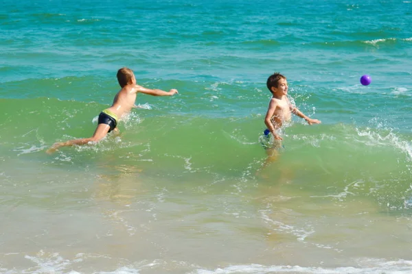 Два брата брызгаются в море. Забавные дети в океане. Семейный отдых — стоковое фото