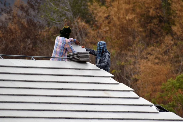 Os trabalhadores colocam as telhas do telhado. Construtores nos trópicos — Fotografia de Stock