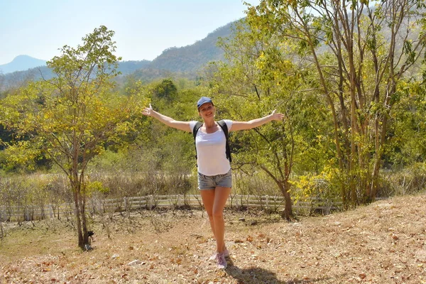 Disfrutando el viaje. Turista un verano en las montañas. Chica viajero con mochila en el bosque. — Foto de Stock