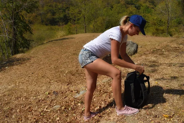 Sportliches Mädchen mit Rucksack in den Bergen. Um einen Ausflug in den Wald zu unternehmen. Aktiver gesunder Lebensstil. — Stockfoto