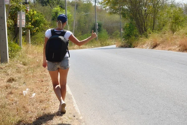 Mujer con estilo de verano en la carretera para el coche. Ir en un viaje. — Foto de Stock