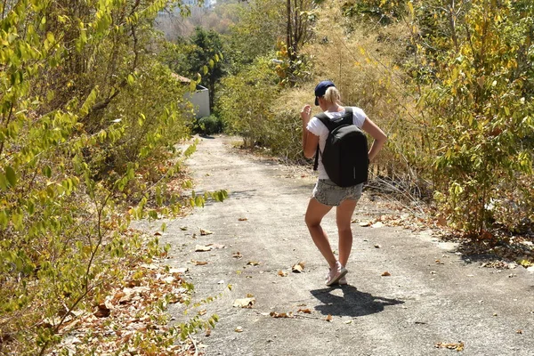 Viajar solo en los trópicos. La chica sube la colina. Aventura autostop sin dinero. — Foto de Stock