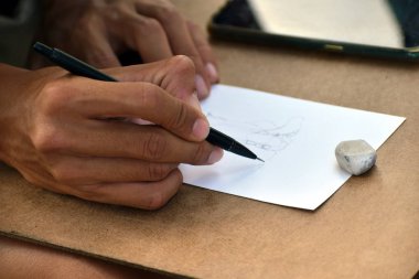 Sokakta çizim yapmak. Sanatçı serbest çalışan biri. Basit bir kalem çizmek için..