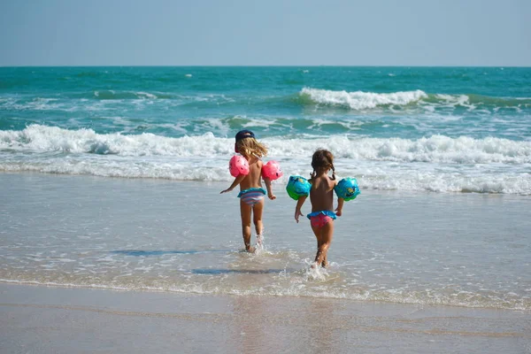 Little girls in swimsuit in the blue sea. Vacation with the kids at the resort. — 스톡 사진