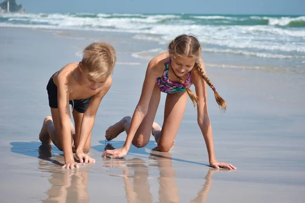 Niños felices juegan juntos en la playa . —  Fotos de Stock
