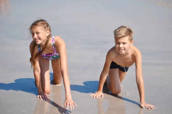 Glada barn leker tillsammans på stranden. — Stockfoto