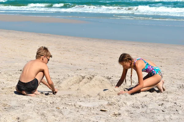 Szczęśliwe dzieci bawią się razem na plaży. — Zdjęcie stockowe