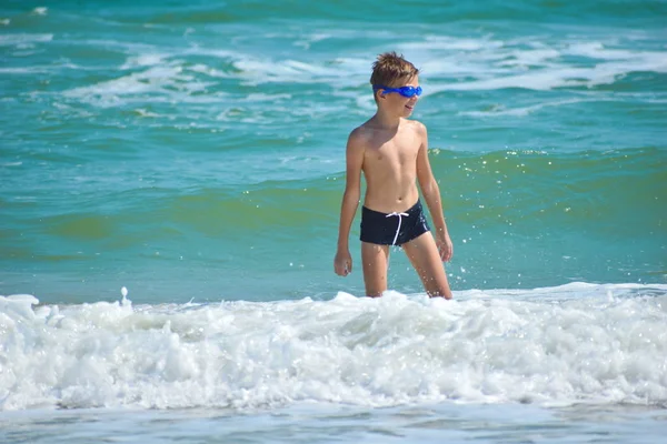 Chłopiec skaczący na falach morskich. Szczęśliwe dziecko w oceanie. — Zdjęcie stockowe