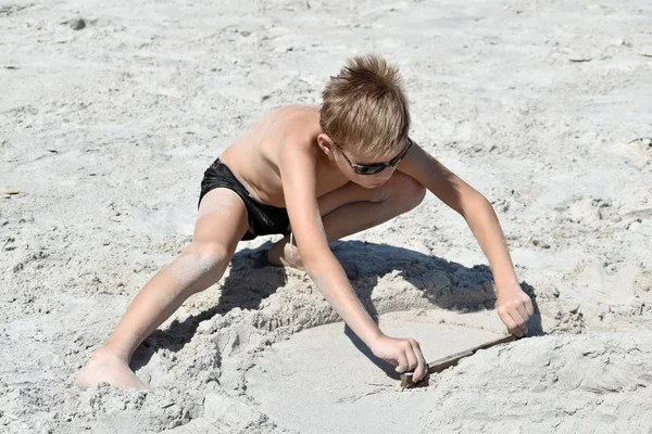 海滩上的小男孩在玩耍。 在海上的水杯里的孩子. — 图库照片