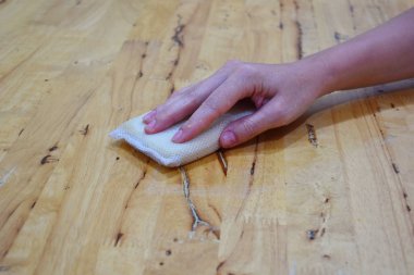 Tahta masayı bir bezle sil. Evi temizleyen bir bez parçasıyla..