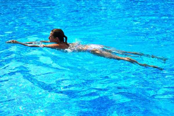 Uma mulher nada na piscina. Magro jovem menina flutua — Fotografia de Stock