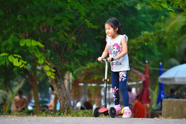 Anak perempuan mengendarai skuter di jalan — Stok Foto