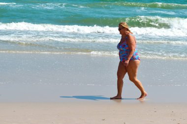 Kumsalda çirkin görünüşlü bir kadın. Koşan kadın figürü.