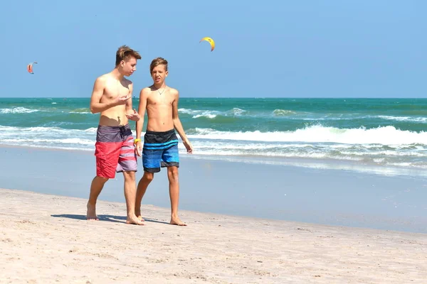 Två vänner går längs stranden på semester. — Stockfoto