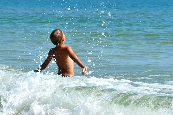 Chlapec si hraje v moři. Užijte si dovolenou v tropech. — Stock fotografie
