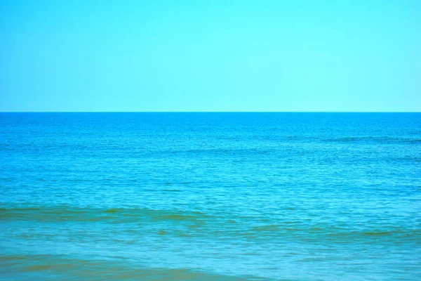 Morskie niebieskie tło. Nadmorski kurort w tropikach. Widok na horyzont oceanu. — Zdjęcie stockowe