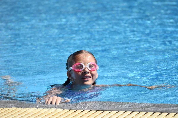 Menina bonito goza de piscina no hotel. adolescente no resort na água. treino de natação. Férias com crianças no mar . — Fotografia de Stock