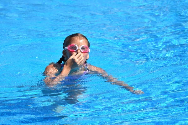 Cute girl enjoys in swimming pool at the hotel.  teenager at resort in water. swimming training. Holidays with children at sea. — 스톡 사진