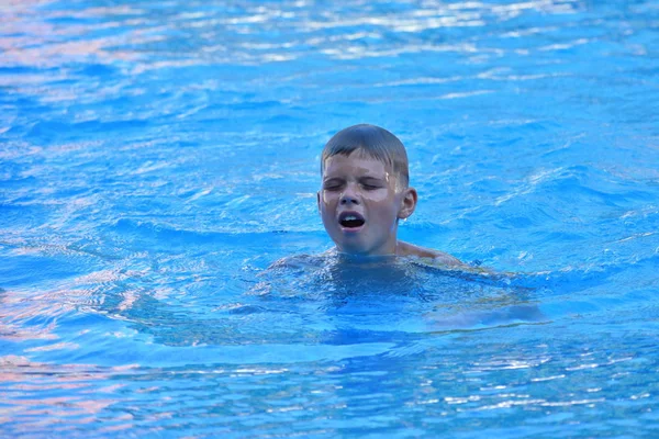 Un niño jugando en el agua del mar. Un niño salta del mar. Unas vacaciones tropicales con niños . — Foto de Stock