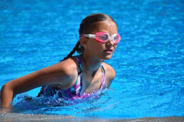 Linda chica disfruta en la piscina en el hotel. adolescente en el complejo en el agua. entrenamiento de natación. Vacaciones con niños en el mar . — Foto de Stock