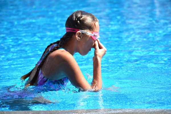 Linda chica disfruta en la piscina en el hotel. adolescente en el complejo en el agua. entrenamiento de natación. Vacaciones con niños en el mar . —  Fotos de Stock