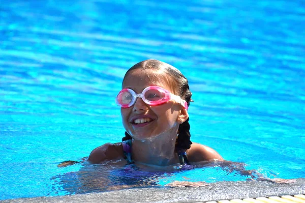 Menina bonito goza de piscina no hotel. adolescente no resort na água. treino de natação. Férias com crianças no mar . — Fotografia de Stock