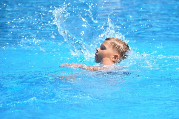 Malý chlapec a vodní sporty. Aktivní dovolená v bazénu. plavecký trénink — Stock fotografie