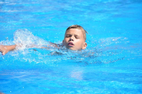 Menino e desportos aquáticos. Férias activas na piscina. prática de natação — Fotografia de Stock