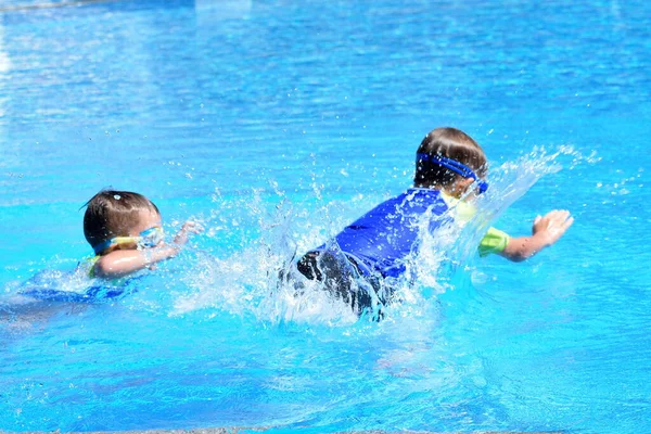 Kleine Jungen springen im Meerwasser. Aktive Wassersportarten für Kinder. — Stockfoto