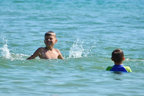 Küçük çocuklar deniz suyuna atlıyor. Çocuklar için aktif su sporları. — Stok fotoğraf