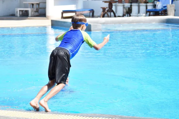 Little boy jumping into the pool. Enjoy the summer vacation autdoor — ストック写真