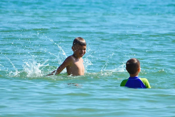 Little boys jumping in the sea water. Active water sports for children. — 스톡 사진