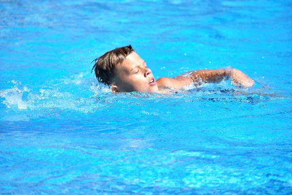 Niño y deportes acuáticos. Vacaciones activas en la piscina. natación práctica — Foto de Stock