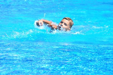 Küçük çocuk ve su sporları. Havuzda aktif tatil. yüzme alıştırması