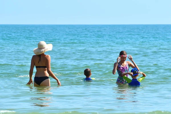 Мати з дітьми плаває в морі. Сімейна відпустка в тропіках — стокове фото