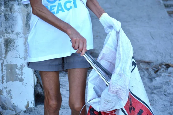 Freiwillige säubern den Strand. , um die Zigarettenstummel am Strand zu sammeln. Freiwillige proberutsya am Ufer. Meeresverschmutzung. — Stockfoto