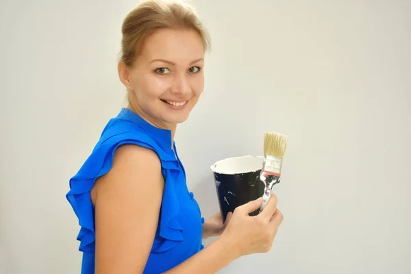 女设计师画。用手粉刷墙壁。修理公寓里的东西那个拿着一罐白漆的女人. — 图库照片