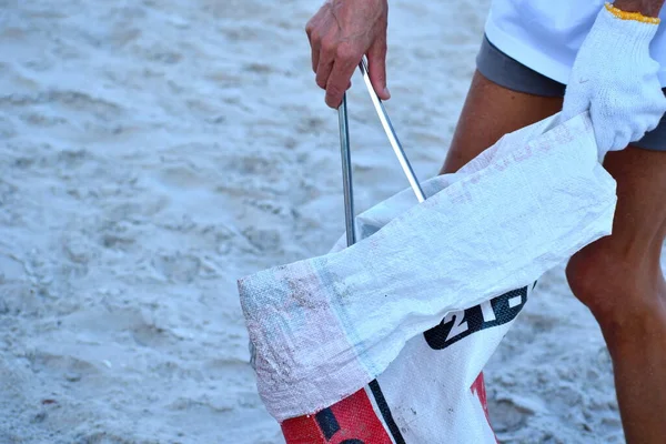 Gönüllüler plajı temizliyor. Sahildeki sigara izmaritlerini toplamak için. Gönüllüler Proberutsya sahilde. Denizin kirliliği.