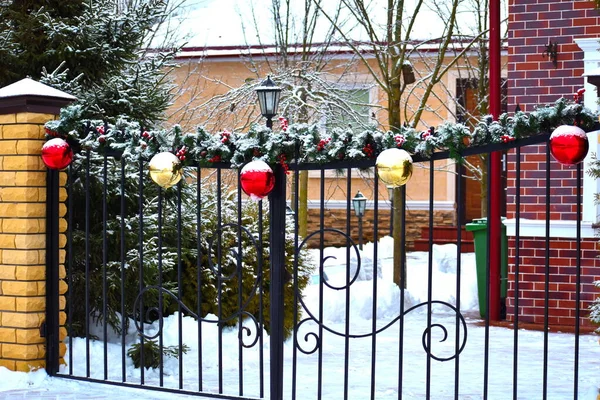 Inverno decoração de Natal na cerca da casa. Belas bolas de anos novos na cerca da casa de campo — Fotografia de Stock