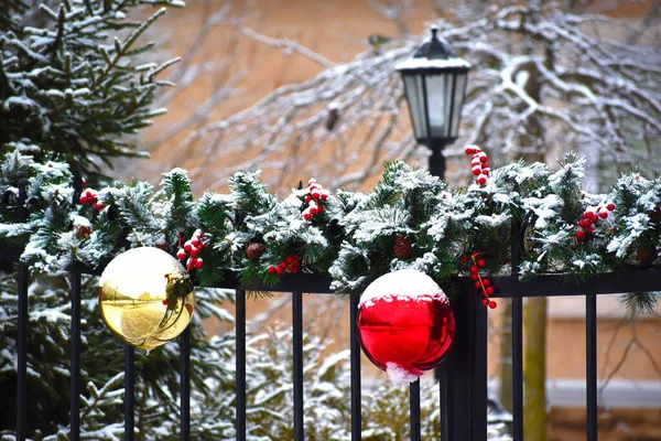 Winter Christmas decoration on the fence of the house. Beautiful New years balls on the fence of the cottage — 스톡 사진
