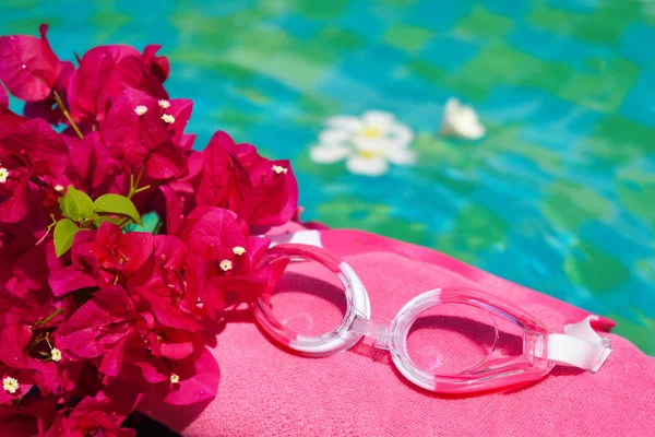 Óculos, uma toalha e flores. Piscina no resort Spa. Relaxe fundo piscina — Fotografia de Stock