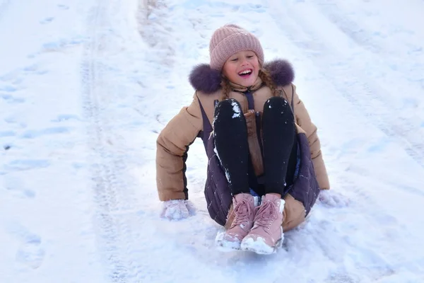 Kindermädchen Kind Winterspaß im Schnee. das Mädchen liegt auf dem Eis. Winter und Schnee genießen. — Stockfoto