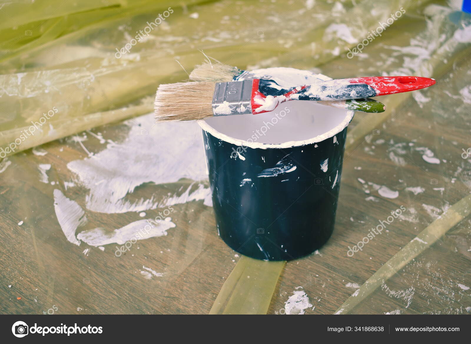 A bucket of white paint and brushes. construction finishing work inside
