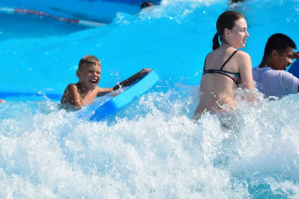 The boy on the waves floating. A fun water Park. water kids games. — Stock Photo, Image