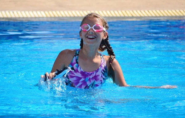 A little girl enjoys swimming in the pool. A water pool in the hotel. Children's summer vacation. — 스톡 사진