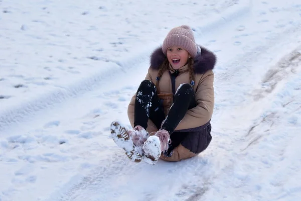 Kindermädchen Kind Winterspaß im Schnee. das Mädchen liegt auf dem Eis. Winter und Schnee genießen. — Stockfoto