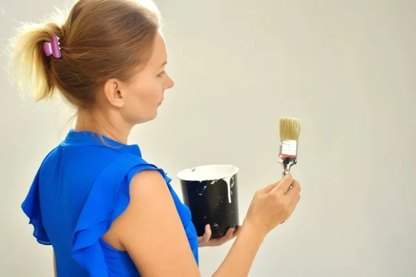 Девушка-дизайнер. покрасить стены руками. Ремонт в квартире. Женщина с банкой белой краски . — стоковое фото