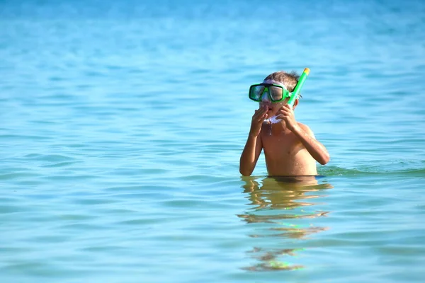 Barnet i havet med havsröret. Dykning till havs. Pojken i glasögonen på havet — Stockfoto