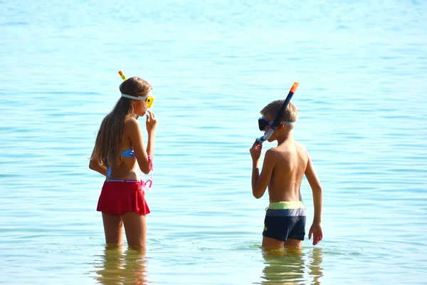 Treasure hunt under water. Children in water glasses in the sea. Children's seaside resort. Children dive under the water. — Stock Photo, Image